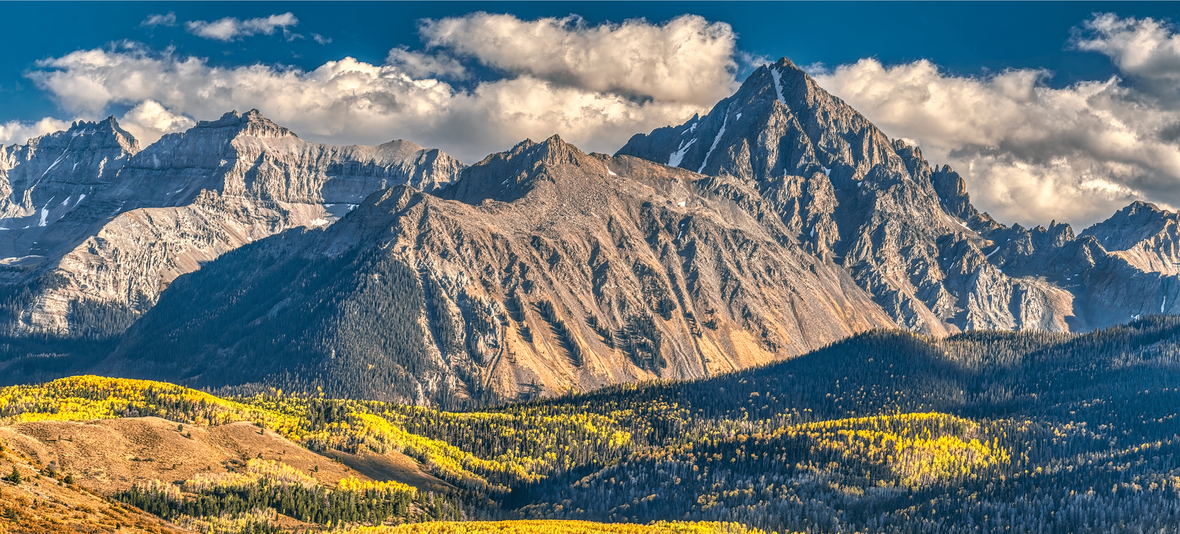 Rugged mountain peaks above autumn forest