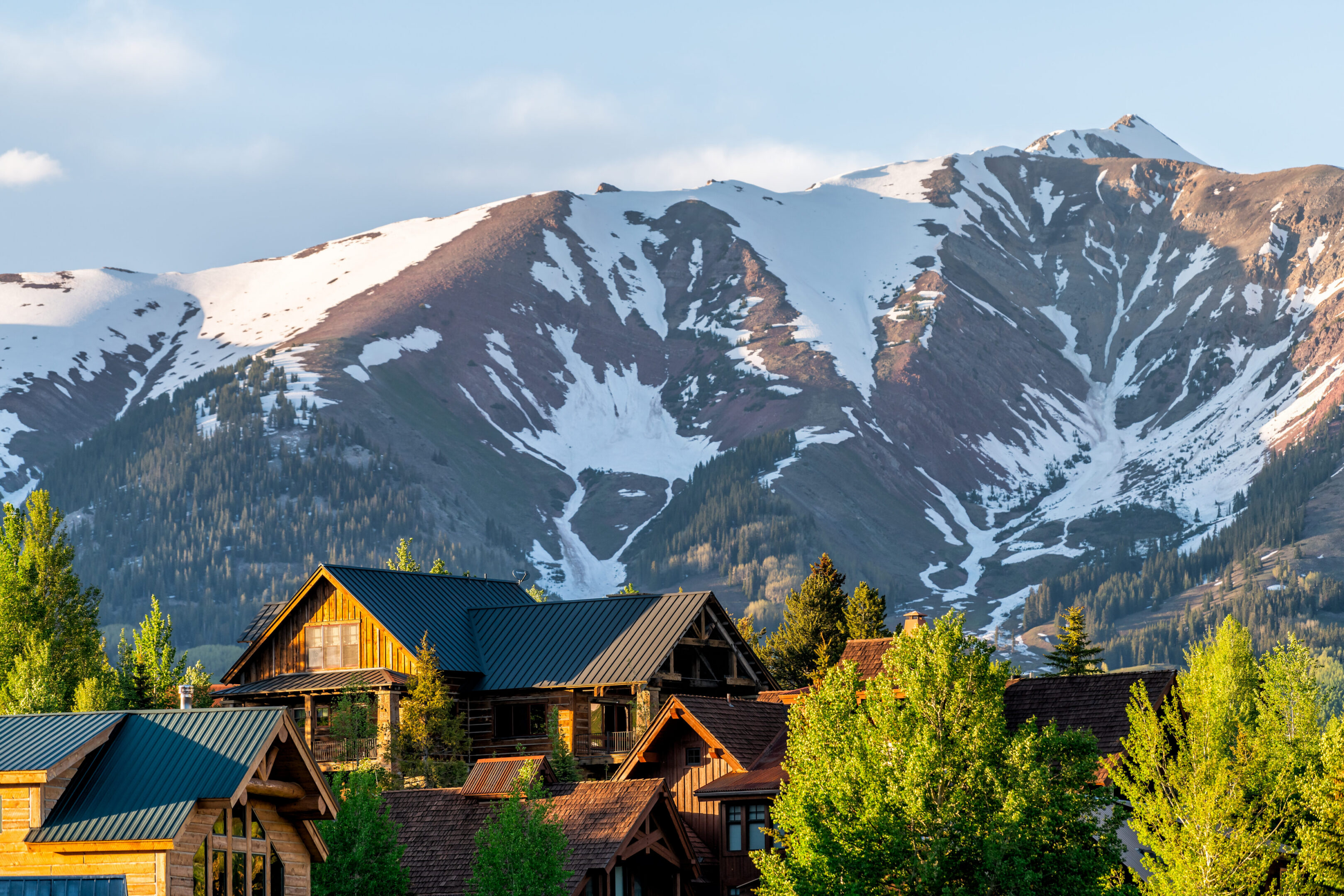 Alpine wooden homes beneath snow-capped mountains