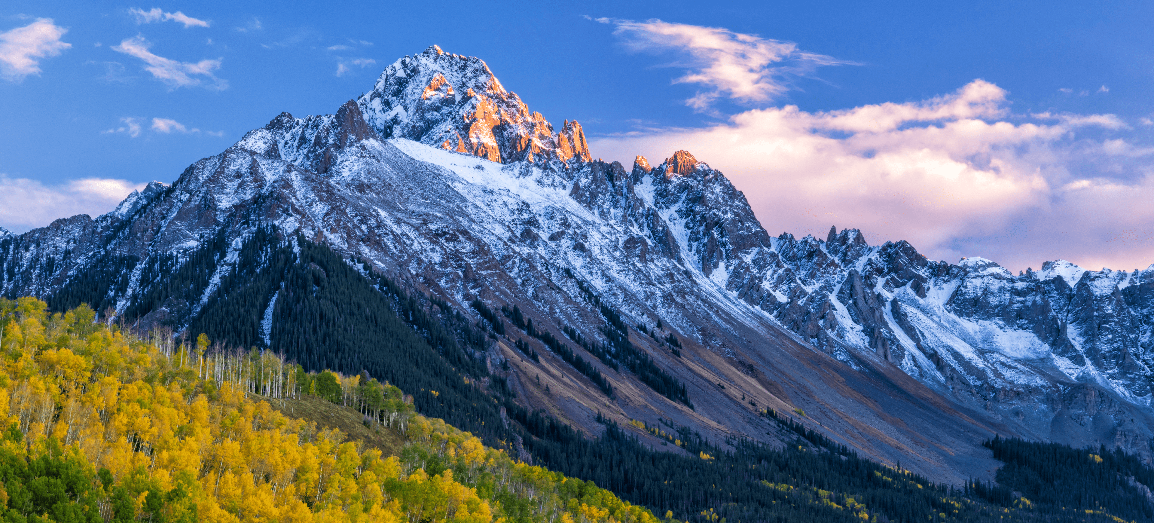Snow-capped mountain with autumn trees
