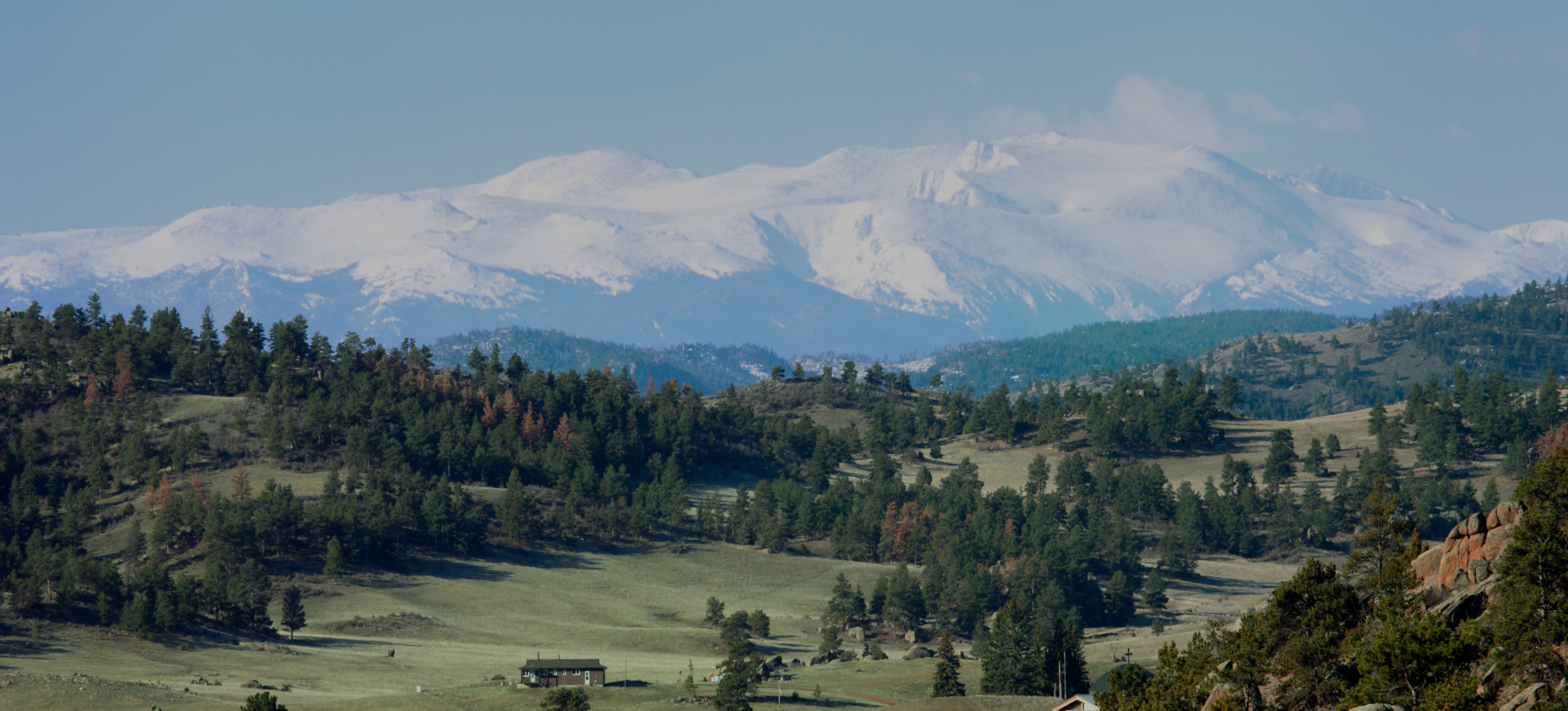 Snow-capped mountains over green valley