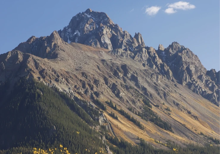 Jagged mountain peak with forested lower slopes