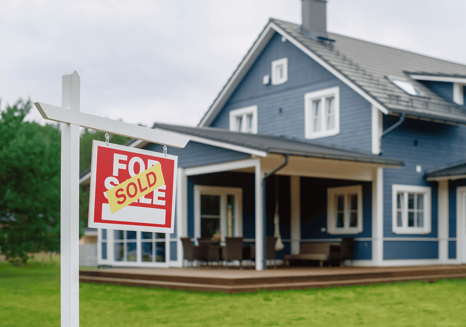 Blue house with sold real estate sign