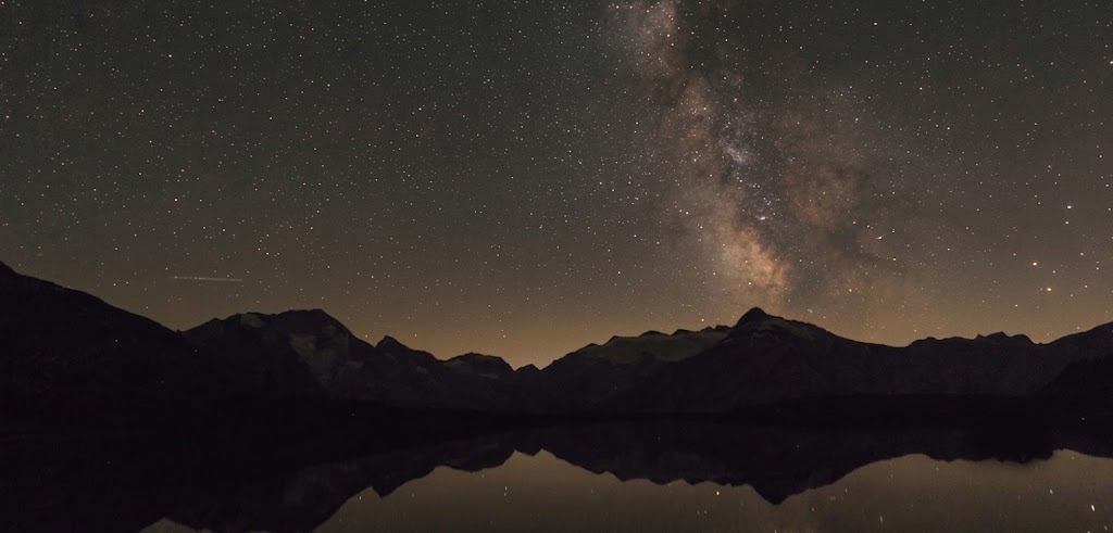 Milky Way over mountain lake reflection at night